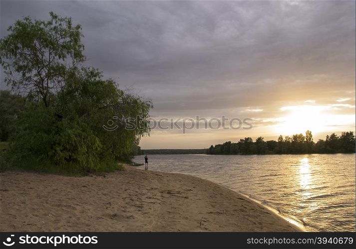 beach on the river at sunset with trees