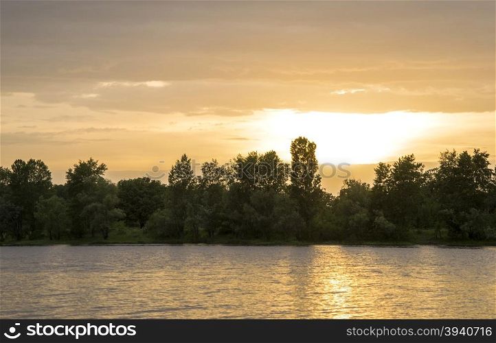 beach on the river at sunset with trees