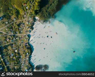 Beach on the shore with white sand and blue water, view from above.. Beach on shore with white sand and blue water, view from above.