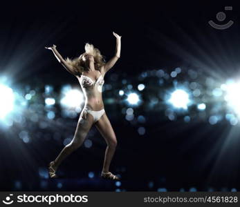 Beach party. Attractive girl in swim wear dancing in party lights