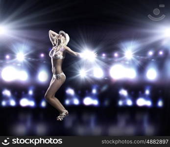 Beach party. Attractive girl in swim wear dancing in party lights