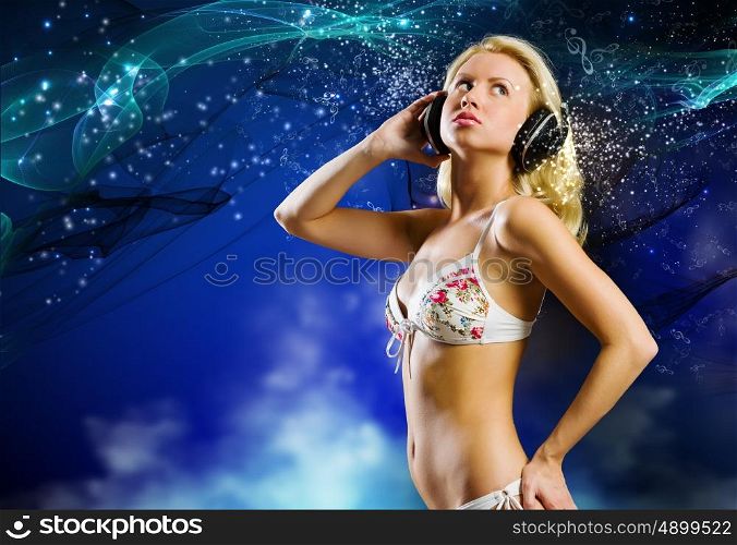 Beach party. Young pretty woman in white bikini wearing headphones