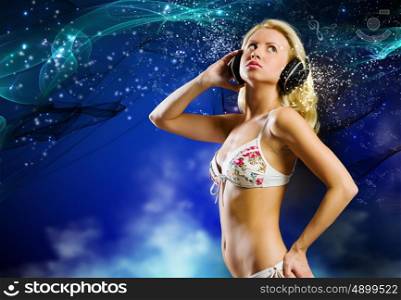Beach party. Young pretty woman in white bikini wearing headphones