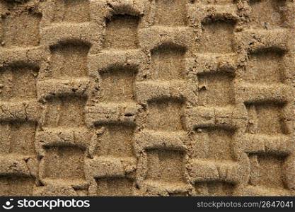 Beach sand texture with vehicle tires footprint background pattern