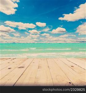 beach sea and blue sky clouds with wood table, vintage tone.