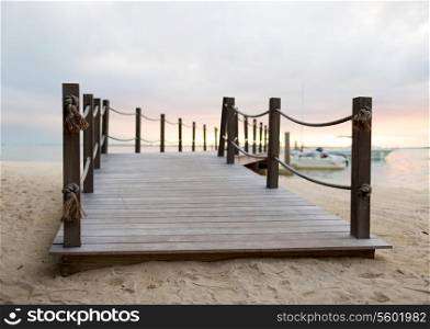 beach, sea, summer and leisure concept - close up of pier on tropical beach