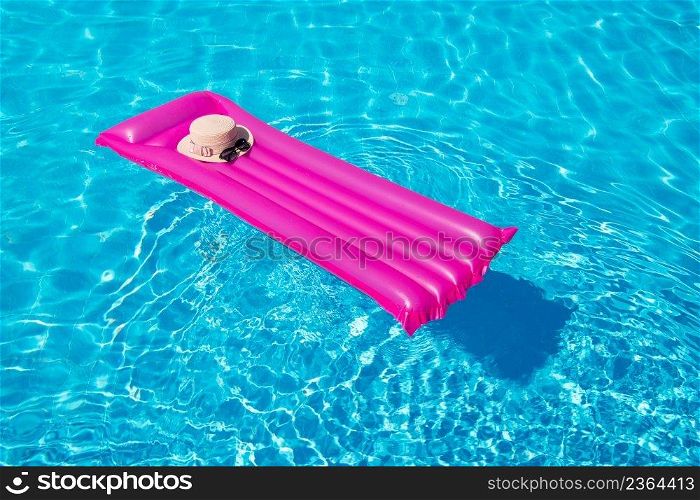Beach summer holiday background. Inflatable air mattress and hat on swimming pool. 