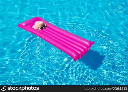 Beach summer holiday background. Inflatable air mattress and hat on swimming pool. 