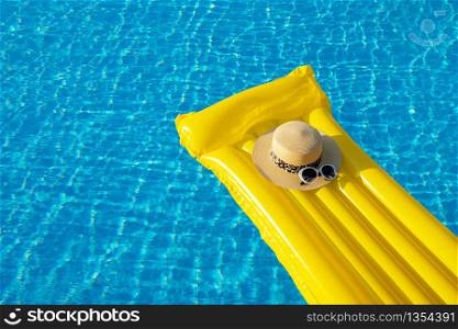 Beach summer holiday background. Inflatable air mattress, hat on swimming pool.