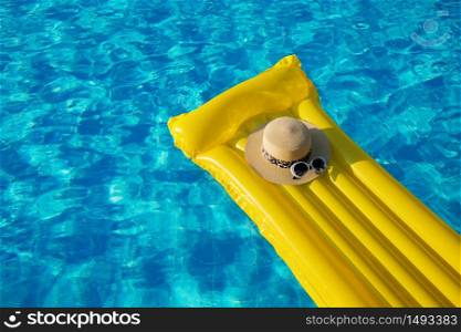 Beach summer holiday background. Inflatable air mattress, hat on swimming pool.