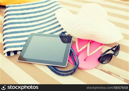 beach, summer, vacation, accessories and technology concept - close up of tablet pc computer and summer accessories on beach