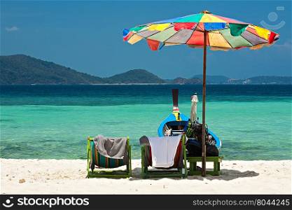 Beach umbrella chairs and boat in Komodo beach in Coral island, Thailand