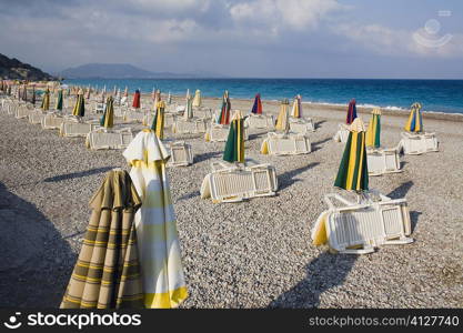 Beach umbrellas and lounge chairs on the beach, Rhodes, Dodecanese Islands, Greece