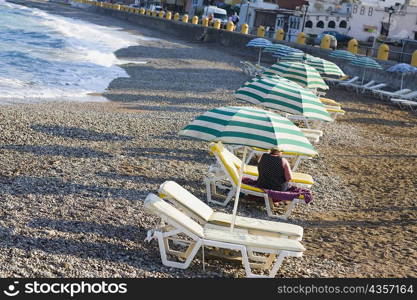 Beach umbrellas and lounge chairs on the beach, Rhodes, Dodecanese Islands, Greece