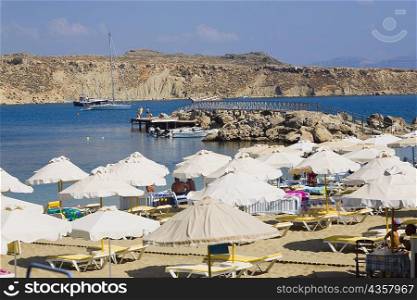 Beach umbrellas on the beach, Lindos, Rhodes, Dodecanese Islands, Greece