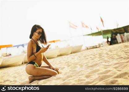 Beach vacation girl using mobile phone during summer travel holiday