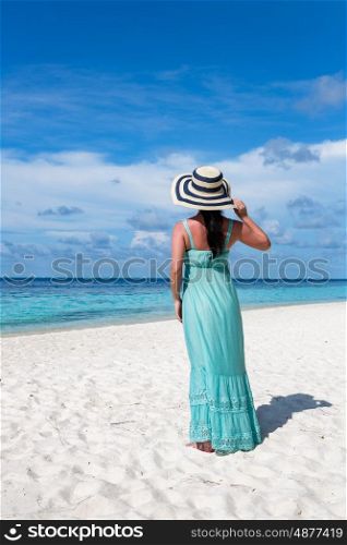 Beach vacation. Girl walking along a tropical beach in the Maldives.