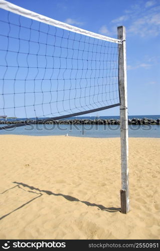 Beach volleyball net in perspective on a sandy beach