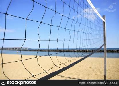 Beach volleyball net in perspective on a sandy beach