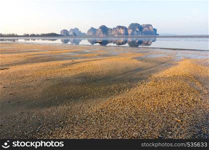 Beach with backdrop of limestone cliffs and reflections, Hua HIn, Trang province, Thailand