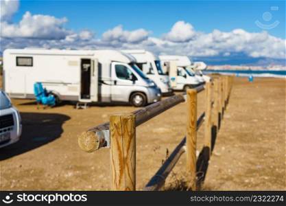 Beach woden fence and caravan c&ing on mediterranean coast, Alicante city in the distance, Costa Blanca Spain. Holidays and traveling in motor home.. Rv motor home c&ing on beach
