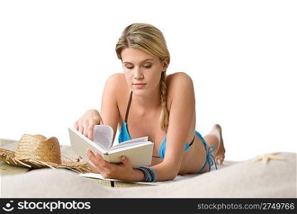 Beach - Young woman in bikini with book lying down sunbathing