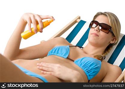 Beach - Young woman in bikini with sunglasses apply suntan lotion