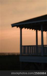 Beachfront porch silhouetted at sunset