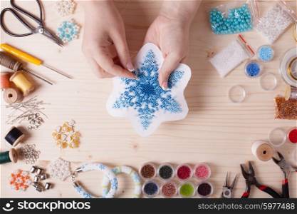 Beaded snowflakes for Christmas tree. Preparation for handmade, top view on the table