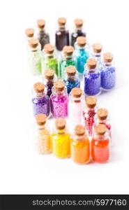 Beads in the vintage mini glass bottles with corks isolated on white. Colorful beads in the bottles