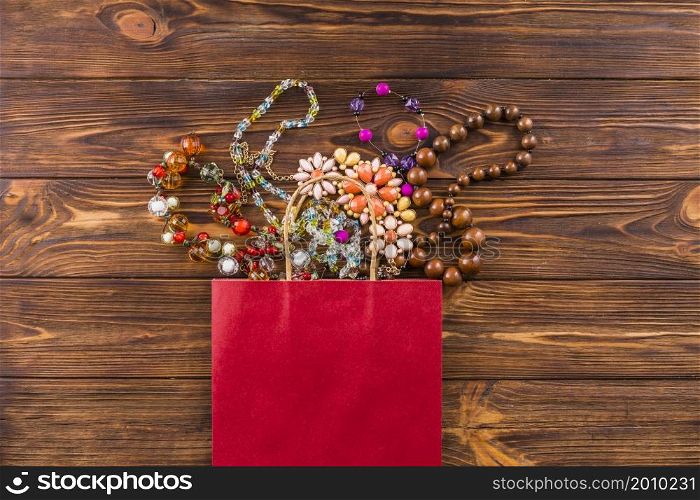 beads jewelry red paper bag wooden background