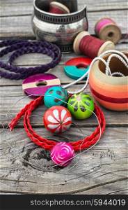 beads on wooden background. Stylish beads and spools of thread on wooden background