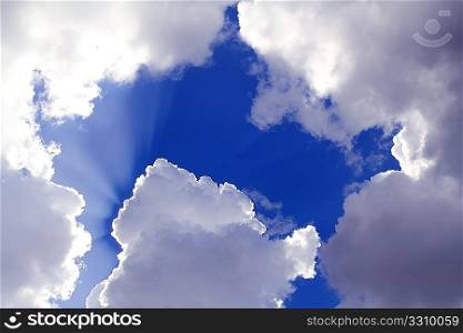 beams from sun in blue sky gray clouds skyscape background