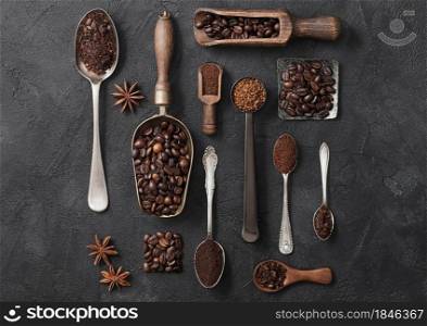Beans and ground coffee and freeze dried instant coffee granules in various spoons and scoops on black background. Macro
