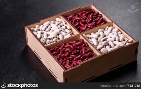 Beans of red and white dry raw beans on a dark concrete background. Cooking Healthy Food. Beans of red and white dry raw beans on a dark concrete background