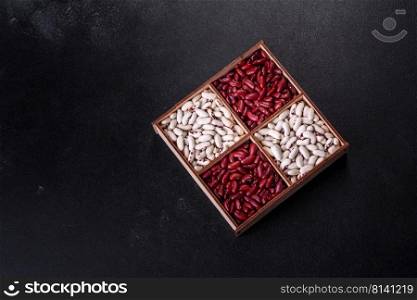 Beans of red and white dry raw beans on a dark concrete background. Cooking Healthy Food. Beans of red and white dry raw beans on a dark concrete background