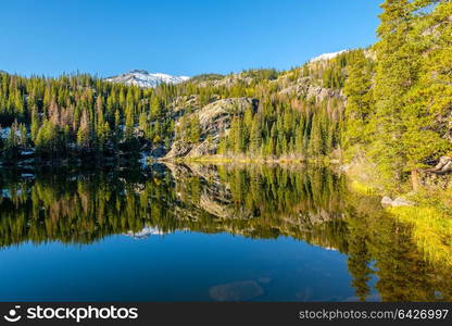 Bear Lake and reflection with mountains in snow around at autumn. Rocky Mountain National Park in Colorado, USA.