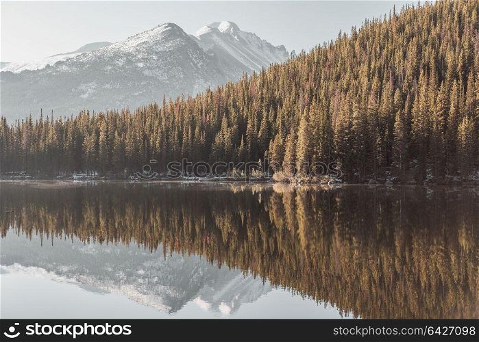 Bear Lake and reflection with mountains in snow around at autumn. Rocky Mountain National Park in Colorado, USA.