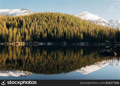 Bear Lake and reflection with mountains in snow around at autumn. Rocky Mountain National Park in Colorado, USA.