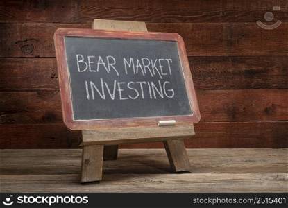 bear market investing - white chalk writing on a slate blackboard, easel sign in a retro classroom, financial concept