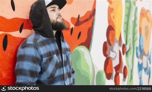 beard man standing front colorful graffiti wall