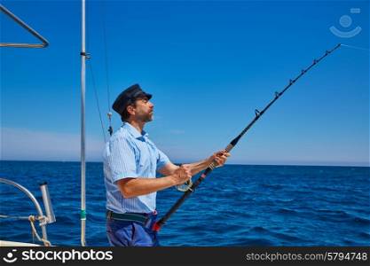 Beard sailor man fishing rod trolling in saltwater in a boat trolling with captain cap