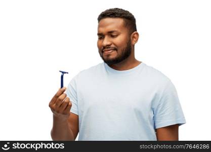 beard shaving, grooming and people concept - african american man with manual razor blade over white background. african american man holding razor blade