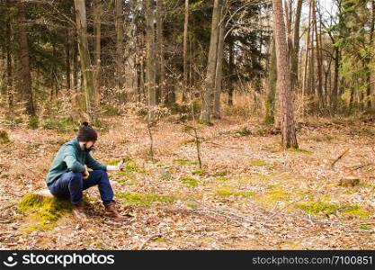 bearded man taking photo with smartphone in the forest
