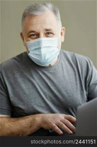 bearded man with surgical mask holding laptop 2