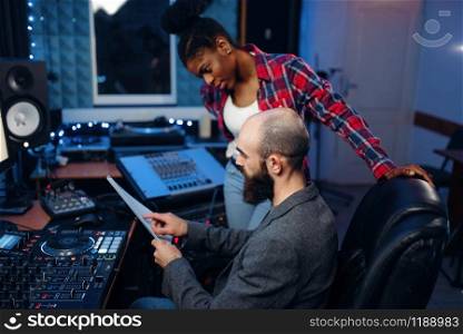 Bearded sound engineer at remote control panel in audio recording studio. Musician at the mixer, professional music mixing. Bearded sound engineer in audio recording studio