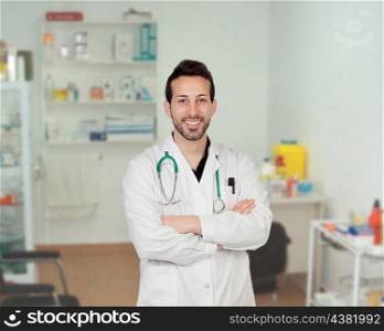 Bearded young doctor in the hospital with the crossed arms