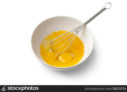 Beaten egg yolks in a bowl with whisk on white background