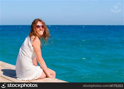beautful woman sitting on the pier