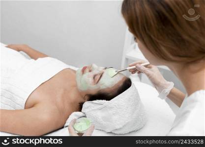 beautician applying face mask female client 5